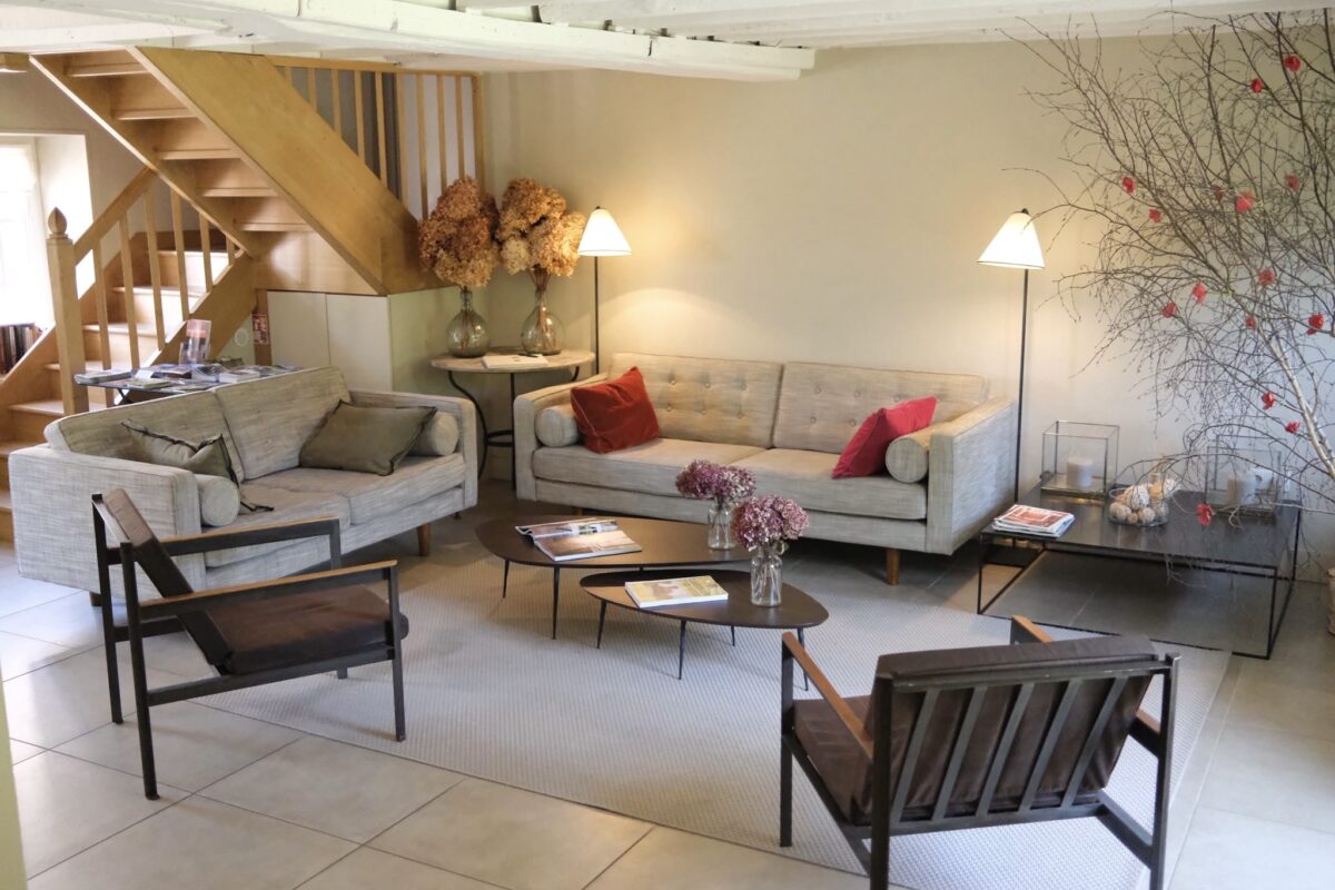 salon des hôtes du Moulin de Vilgris avec cheminée, fauteuils confortables et ambiance chaleureuse